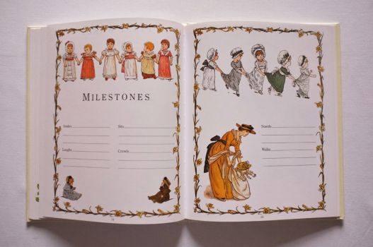 Pages 34 and 35 of The Kate Greenaway Baby Book are illustrated with garlands of daffodils, lines of children, a mother helping her daughter take her first steps and space to write down details of Milestones such as when your child first smiled, laughed, crawled and walked. 