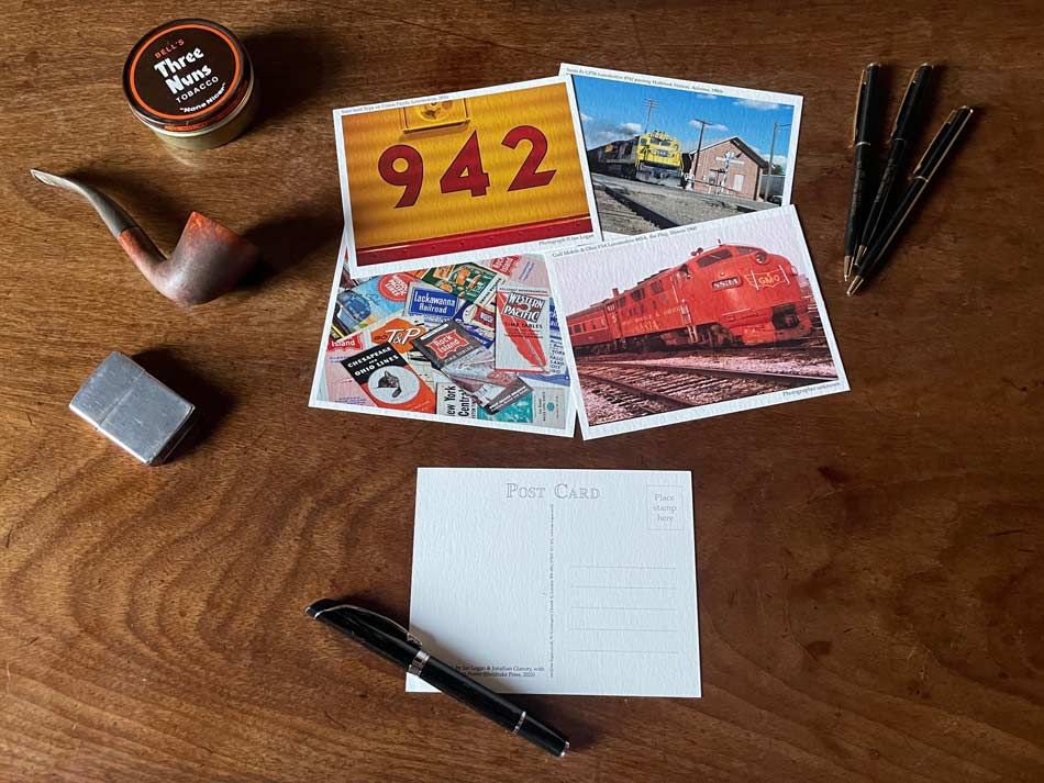 Postcards are laid out on a table, with one selected for writing. 