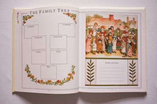 Pages 14 and 15 of The Kate Greenaway Baby Book have a family tree ready to be filled in and a portrait of village families amid garlands of flowers and leaves.
