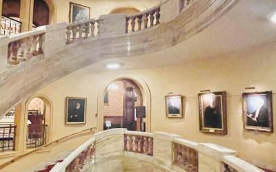 A colour photograph captures the graceful, cantilevered curves of the Grand Staircase at the National Liberal Club.