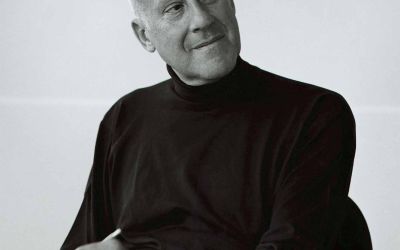 The architect Norman Foster sits with pencil and sketch book in this black-and-white portrait, courtesy of GA/Yukio Futagawa.