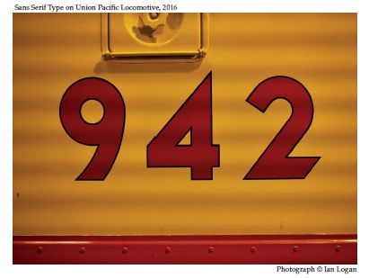 In this colour photograph taken by the railfan designer Ian Logan, the number 942 is painted in red with a fine black border in a bold sans serif type on the rich Armour Yellow bodywork of a Union Pacific locomotive.