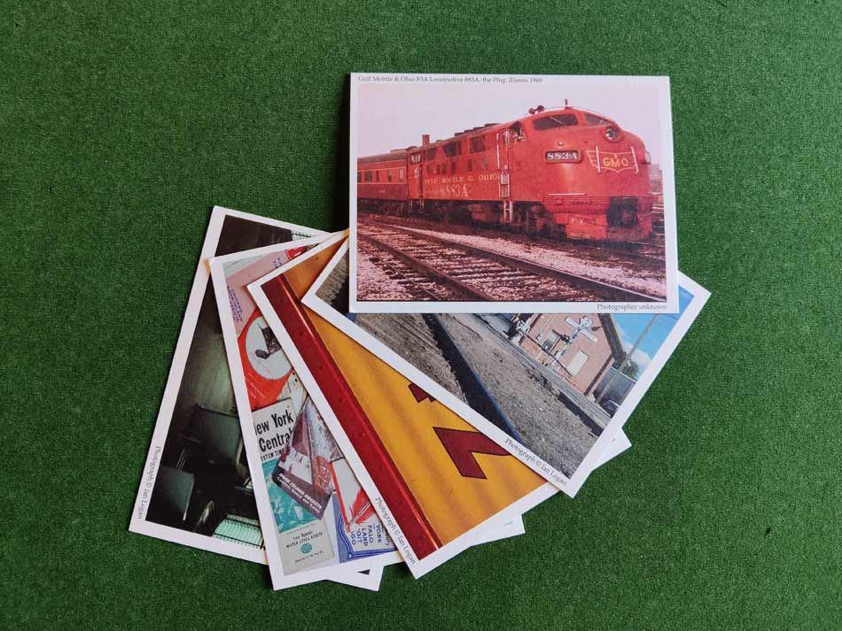 This colour image shows five railway-themed postcards on a green background arranged in a fan from top right to bottom left.
