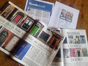 In this colour photograph, various magazine spreads and printed articles are laid across a desk.