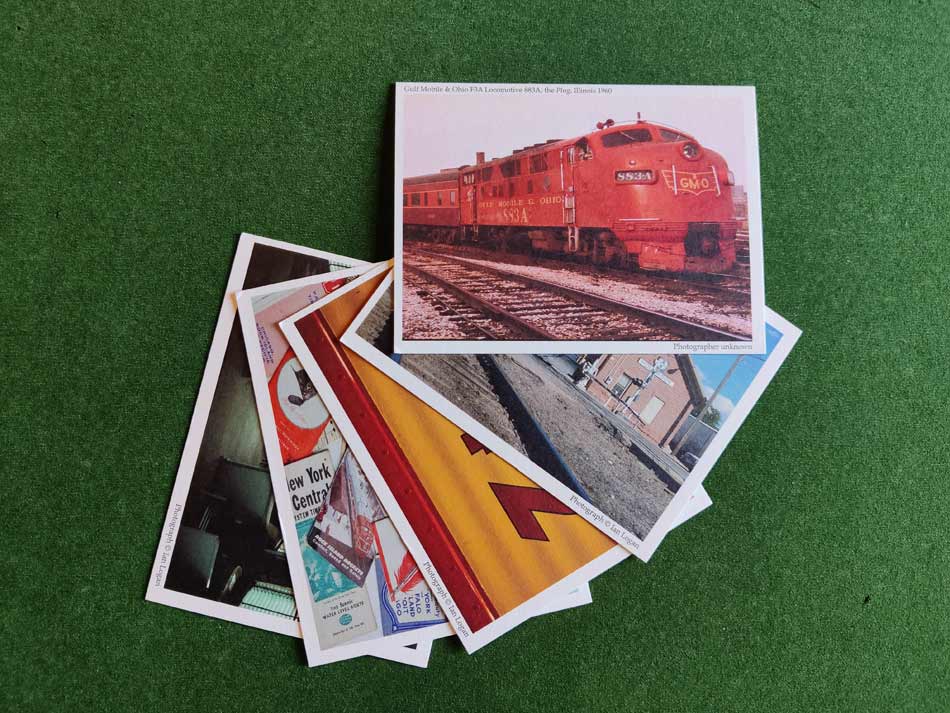 This colour image shows five railway-themed postcards on a green background arranged in a fan from top right to bottom left.