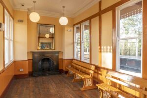 Hanwell Station waiting room is made of wood painted brown and cream.