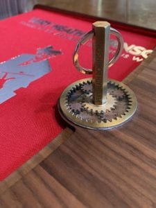 Colour photo of Super De Luxe Presentation Box open with close-up of brass hexagonal key in brass cog wheels of lock.