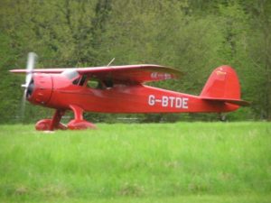 In this colour photograph Ian Logan lands one of his magnificent machines, a 1940 Cessna Airmaster, on a grass runway at Popham Airfield in Hampshire.