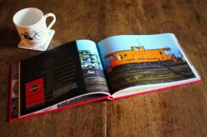 Logomotive open beside a cup of coffee, displaying a double-page spread on the Illinois Central Gulf railroad.