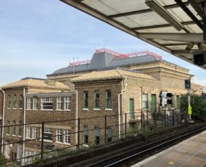 Colourful iron cresting tops the mansard roof of Peckham Rye station.
