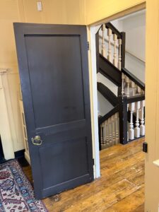 In this colour photograph taken on the second floor of Dr Johnson’s house, a panelled door leads from the library to the staircase. 