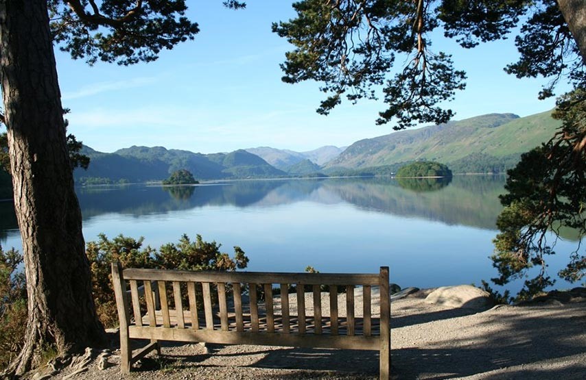 Photograph of Derwentwater with a bench on the shore.