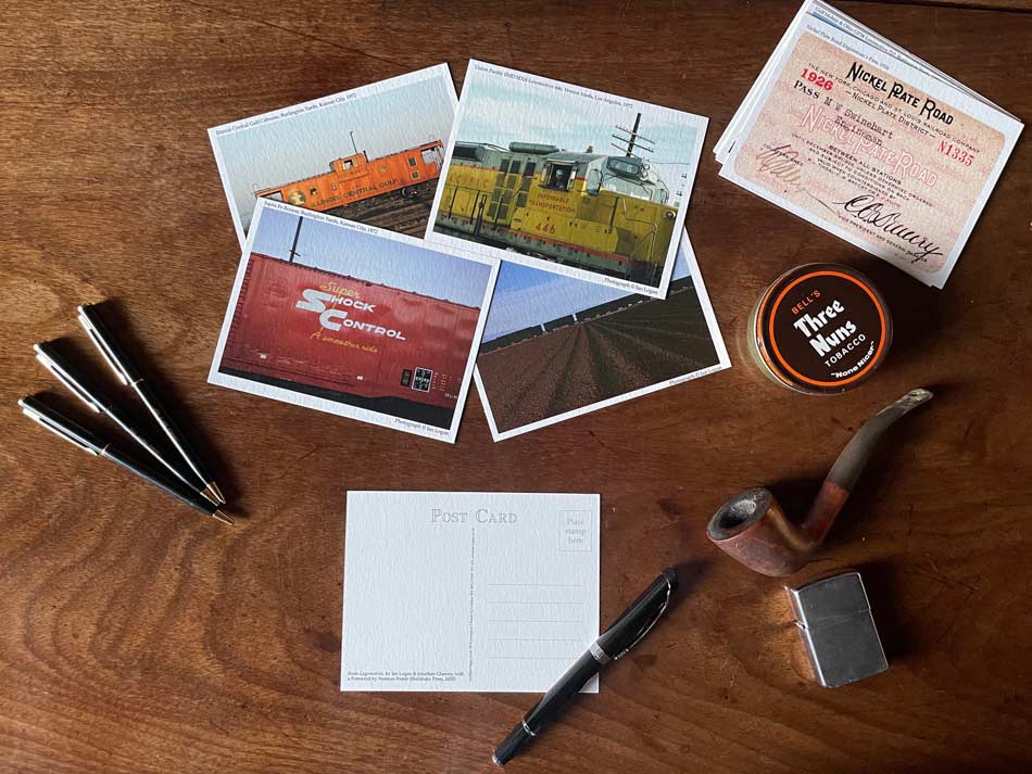 Postcards are laid out on a table, with one selected for writing.