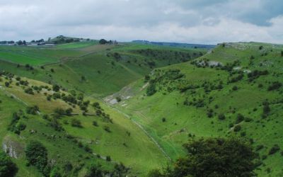 A colour photograph taken by Peter Kochut in 2004 provides a view down into Cressbrook Dale, flanked by rocky outcrops and partly clothed in woodland.