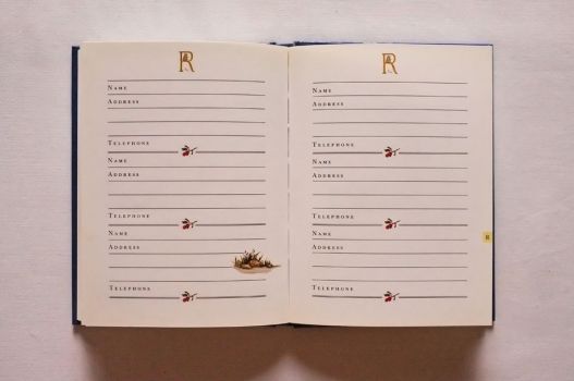 Spaces for six names, addresses and telephone numbers are provided on these pages, beneath header images of a girl reading on the letter R while her cat waits.