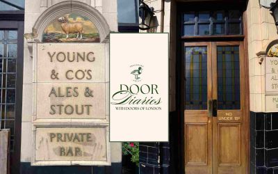 The wooden front door of the Ram Inn, as photographed by Cath Harries in Doors of London, is positioned to the right of a glazed terracotta Young & Co’s sign, prominently featuring the Young family pet ram, RamRod D’Arcy. The two serve as a backdrop to the Door Diaries logo, a graphic featuring dark green text and the Sheldrake Press logo on a cream-coloured background, with a green rectangular frame.