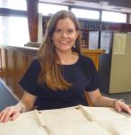 In this colour photograph the house historian Melanie Backe-Hansen studies property deeds sealed with red wax in the City of Westminster Archives.