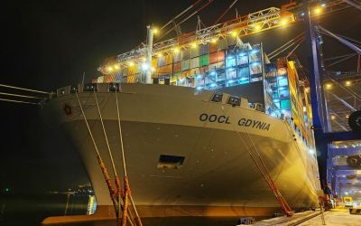 In a colour photograph by Marian Polytsiak the OOCL Gdynia is brightly lit by arc lights as it waits for its stacks of containers to be unloaded in port.